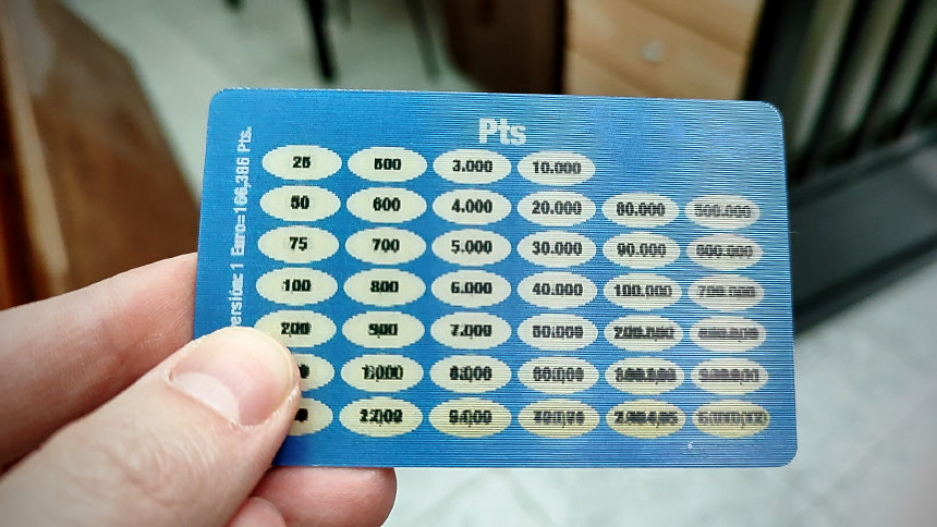 Fotografia d’una mà que sosté una targeta lenticular que conté una taula de conversió de pessetes a euros.